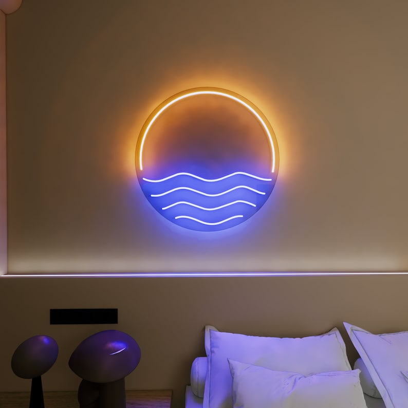 Puede incluir: Un letrero de ne&oacute;n con un dise&ntilde;o de ola azul dentro de un c&iacute;rculo amarillo. El letrero est&aacute; montado en una pared beige sobre una cama con almohadas blancas.