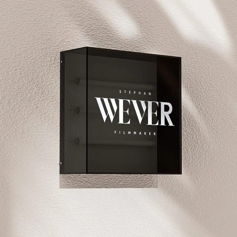 May include: A black square sign with white text that reads "Stephan Wever Filmmaker".