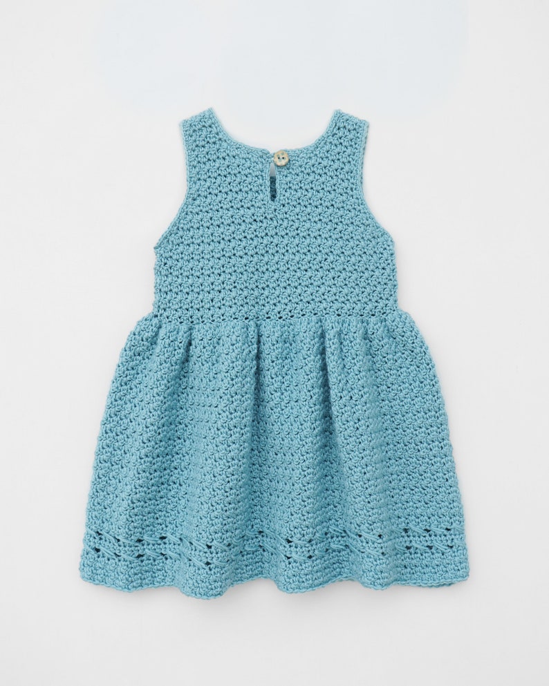May include: A light blue crocheted dress with a sleeveless design and a gathered skirt. The dress has a button closure at the back.