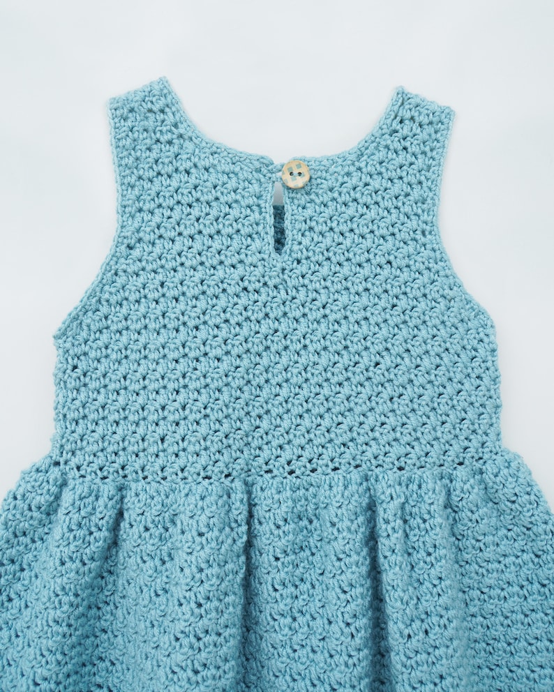 May include: A light blue crocheted dress with a button on the back.