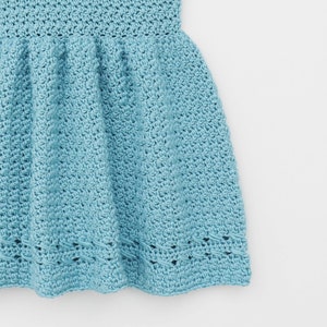 May include: A light blue crocheted dress with a ruffled skirt and a delicate lace trim.
