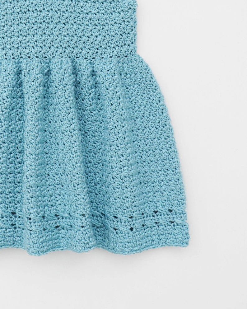 May include: A light blue crocheted dress with a ruffled skirt and a delicate lace trim.