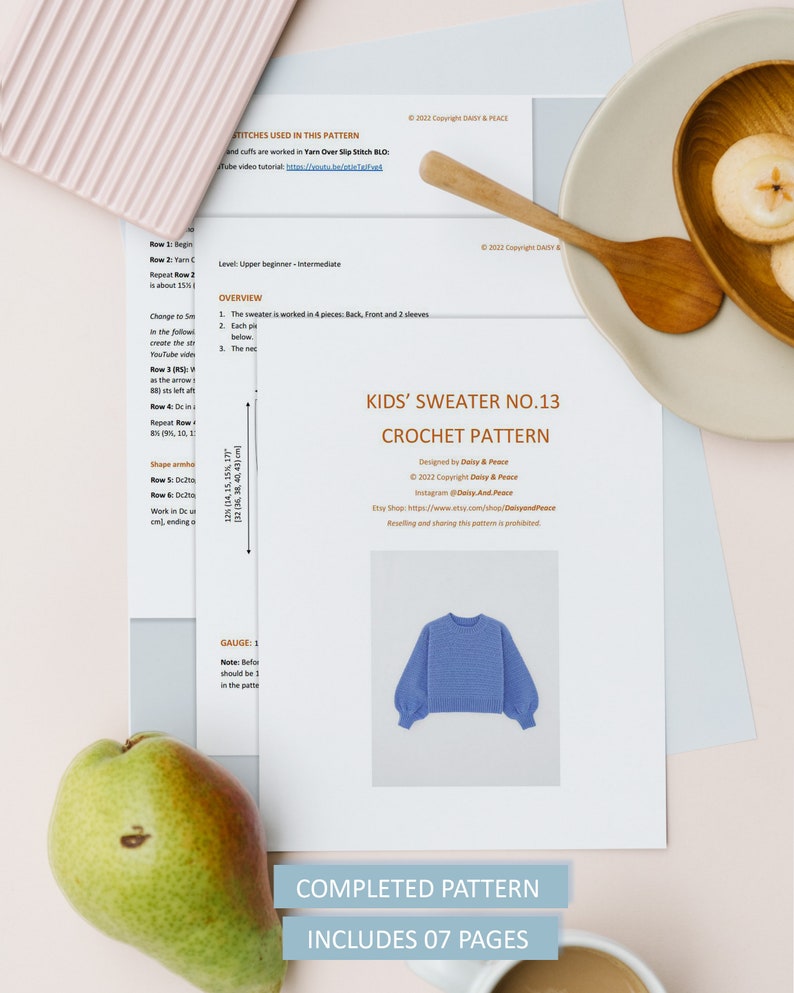 May include: A crochet pattern for a kids' sweater, titled "Kids' Sweater No. 13 Crochet Pattern". The pattern is designed by Daisy & Peace and includes 7 pages. A blue sweater is shown in the image.