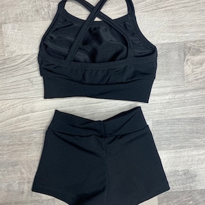 Peut inclure: Haut de danse noir &agrave; bretelles crois&eacute;es dans le dos et short de danse noir assorti.