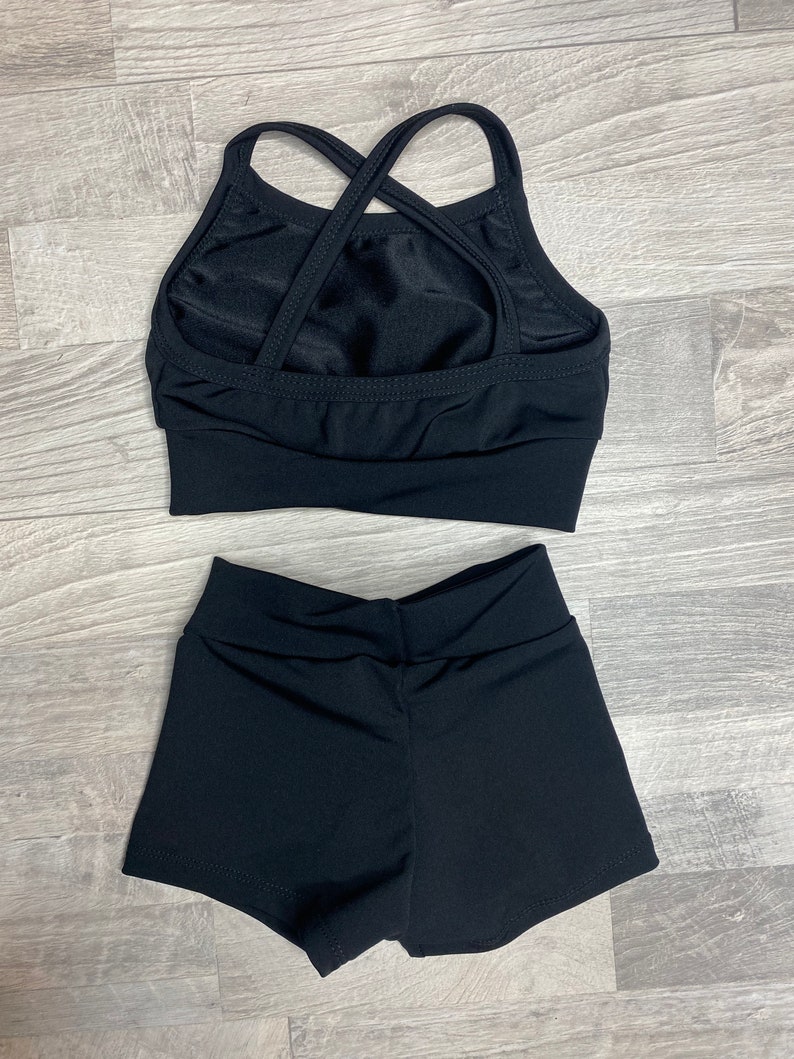 Peut inclure: Haut de danse noir &agrave; bretelles crois&eacute;es dans le dos et short de danse noir assorti.