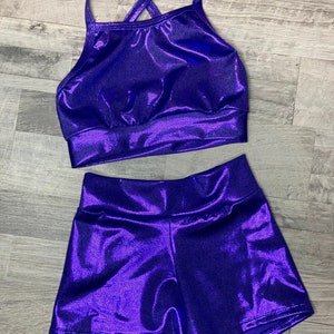 Peut inclure: Un ensemble de haut et de short en m&eacute;talliques violet. Le haut a un design de bretelles crois&eacute;es et le short a une taille haute.