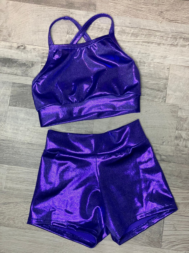 Peut inclure: Un ensemble de haut et de short en m&eacute;talliques violet. Le haut a un design de bretelles crois&eacute;es et le short a une taille haute.