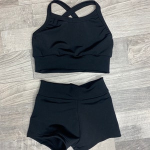 Peut inclure: Un haut de danse noir avec une bretelle arri&egrave;re crois&eacute;e et un short de danse noir.