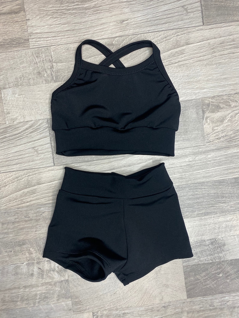 Peut inclure: Un haut de danse noir avec une bretelle arri&egrave;re crois&eacute;e et un short de danse noir.