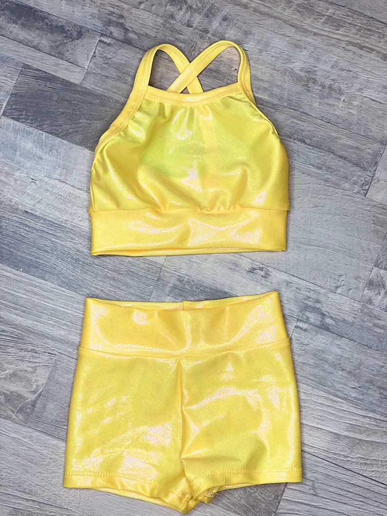 Peut inclure: Un haut de maillot de corps jaune brillant avec un dos crois&eacute; et un short assorti. Le tissu a un l&eacute;ger chatoiement.