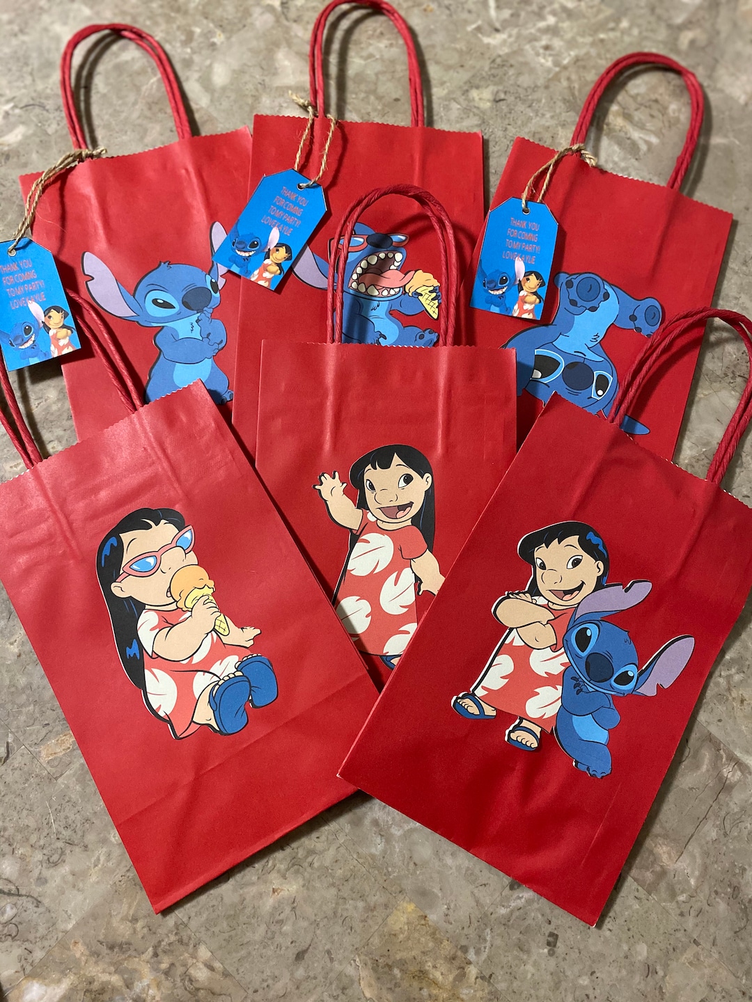 DIY Stitch goodie bags for birthday party! Cut out & glued stitch's face &  tied with…