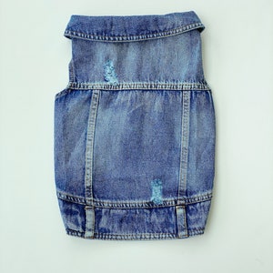 May include: A blue denim vest with distressed details. The vest has a collar and two pockets.