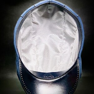 May include: A blue and black baseball cap with a mesh lining. The cap has a curved brim and a small logo on the front.