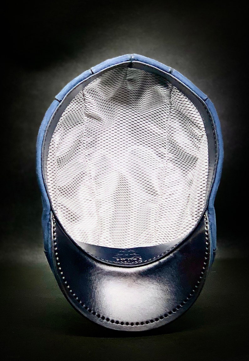 May include: A blue and black baseball cap with a mesh lining. The cap has a curved brim and a small logo on the front.