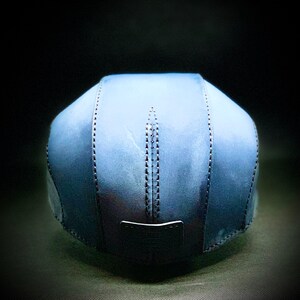 May include: A blue denim baseball cap with a stitched seam detail. The cap has a flat brim and a structured crown.
