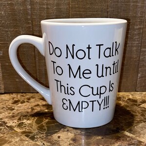 May include: White ceramic coffee mug with a black handle and the text "Do Not Talk To Me Until This Cup Is EMPTY!!" printed on the side.
