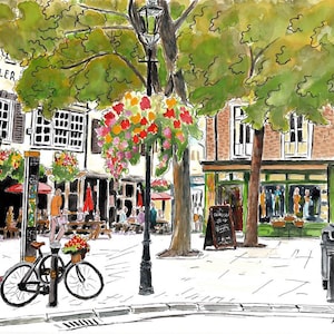 May include: Watercolour painting of a town square with a bicycle, a red telephone box, and a pub. The scene includes hanging flower baskets, trees, and people. Buildings have white window frames and awnings. The artist's signature is visible.