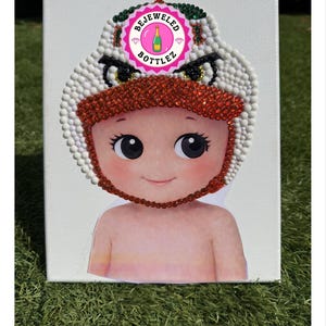 Może przedstawiać: Biały ceramiczny kubek z czarnym uchwytem i napisem "But First, Coffee" w stylu odręcznym. Kubek stoi na białej powierzchni. Kubek ma około 10 cm wysokości.