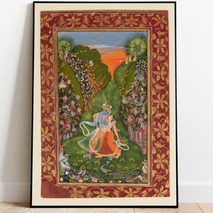 May include: Framed artwork with an Indian miniature painting. The image shows two figures embracing in a garden, surrounded by plants and animals. The painting has a decorative red and gold border, enhancing its ornate style. The artwork is framed.