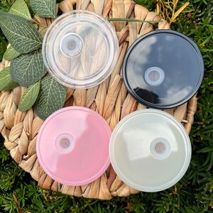 May include: Four round lids for a tumbler or cup. The lids are in four colors: clear, black, pink, and white. Each lid has a small hole in the center.