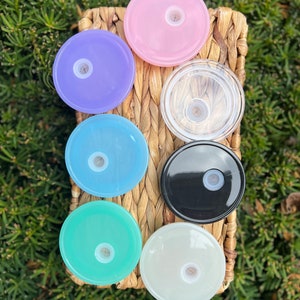 May include: Seven different colored plastic lids for a tumbler or cup. The lids are in a variety of colors, including pink, purple, blue, green, white, black, and clear.