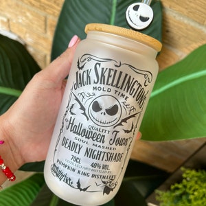 May include: A white frosted glass tumbler with a bamboo lid and a black and white Jack Skellington design. The tumbler has the text "Jack Skellington's Mold Time" and "Halloween Town" with a skull and crossbones graphic. The text "Soul Mashed Deadly Nightshade" is also on the tumbler. The tumbler has a black and white straw with a Jack Skellington head on the top.