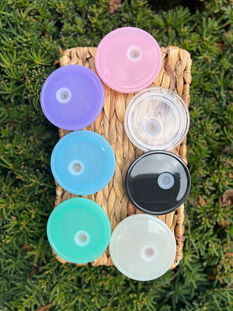 May include: Seven different colored plastic lids for a water bottle. The lids are in a variety of colors, including pink, purple, blue, light blue, green, black, and white.