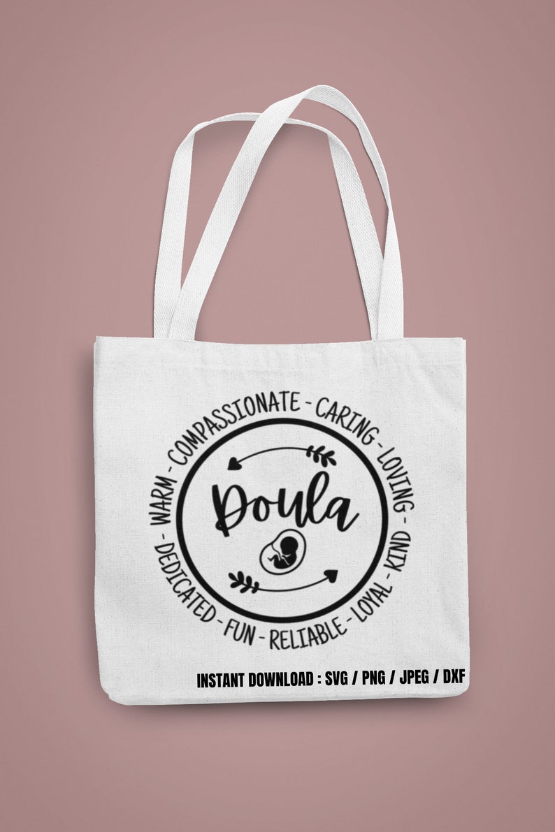 May include: White tote bag with black text and a circular design. The design includes the word "Doula" and surrounding words like "Compassionate" and "Caring". An image of a fetus is in the center. The bag has two white handles.