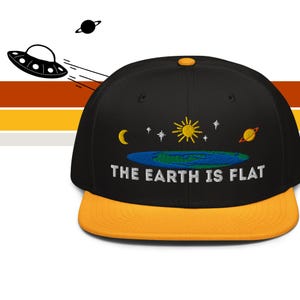 May include: Black and yellow flat-brimmed baseball cap with the embroidered phrase "THE EARTH IS FLAT." The cap features a yellow brim and a design of the sun, moon, stars, and a planet. An illustration of a UFO and a planet are in the background.
