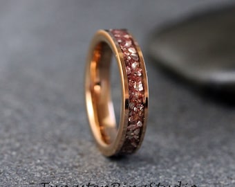 May include: A rose gold tungsten carbide ring with a band of embedded red and white stones.