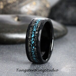 May include: A black tungsten carbide ring with a blue and silver inlay. The ring has a hammered finish.