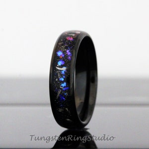 May include: Black tungsten carbide ring with a blue, pink and silver glitter inlay.