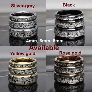 May include: Three stacked rings in silver-gray, black, yellow gold, and rose gold with a black and white speckled pattern. The rings are available in 4mm, 6mm, and 8mm widths.