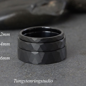 May include: Three black tungsten carbide rings stacked on top of each other. The rings are 2mm, 4mm, and 6mm wide. The rings have a hammered finish.