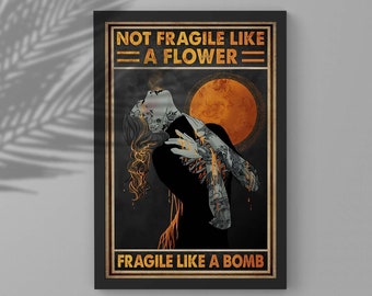 May include: A vintage-style poster with a woman with tattoos and a fiery background. The text reads "Not Fragile Like A Flower - Fragile Like A Bomb".