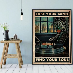 May include: A vintage-style poster with a person sitting in a chair with musical notes swirling around their head. The person is listening to a record player. The poster says "Lose Your Mind Find Your Soul".