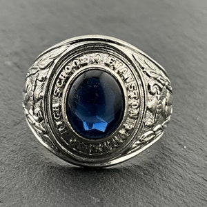 May include: A silver class ring with a blue stone and the inscription "High School of Evanston 1953".