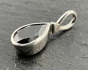 以下が含まれることがあります： 涙の形をした黒い宝石が付いたシルバーのペンダント