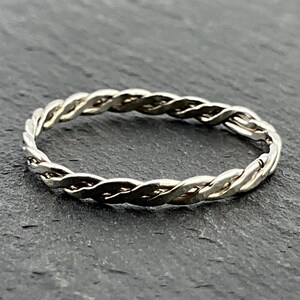 May include: A silver braided ring with a twisted design.