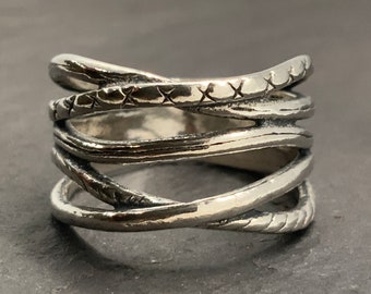 May include: A silver ring with a woven design. The ring is made of multiple bands of silver that are intertwined.