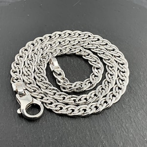 May include: A silver chain necklace with a box clasp. The chain is made of multiple strands of linked metal.