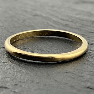 Könnte beinhalten: Ein dünner, polierter Goldring mit einem glatten, abgerundeten Profil. Auf der Innenseite des Rings befindet sich eine sichtbare Punzierung mit der Aufschrift 14KS, die die Metallzusammensetzung dieses schlichten, kreisförmigen Schmuckstücks angibt.