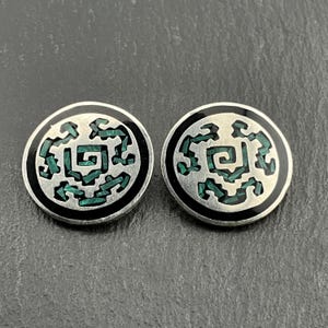 May include: A pair of silver earrings with a black enamel border and a green malachite inlay in the shape of a geometric design.
