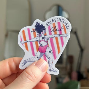May include: A sticker with a cartoon illustration of a person in a pink swimsuit with star tattoos, arms outstretched. The figure is set against a heart-shaped background with orange and pink stripes. The text "SALBSCHTLI&Auml;BI Club" is above the figure.