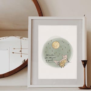 May include: A framed print with a green watercolor background and a gold moon. The print features a line drawing of a person with long hair, with the text "Fall in love with taking care of yourself".