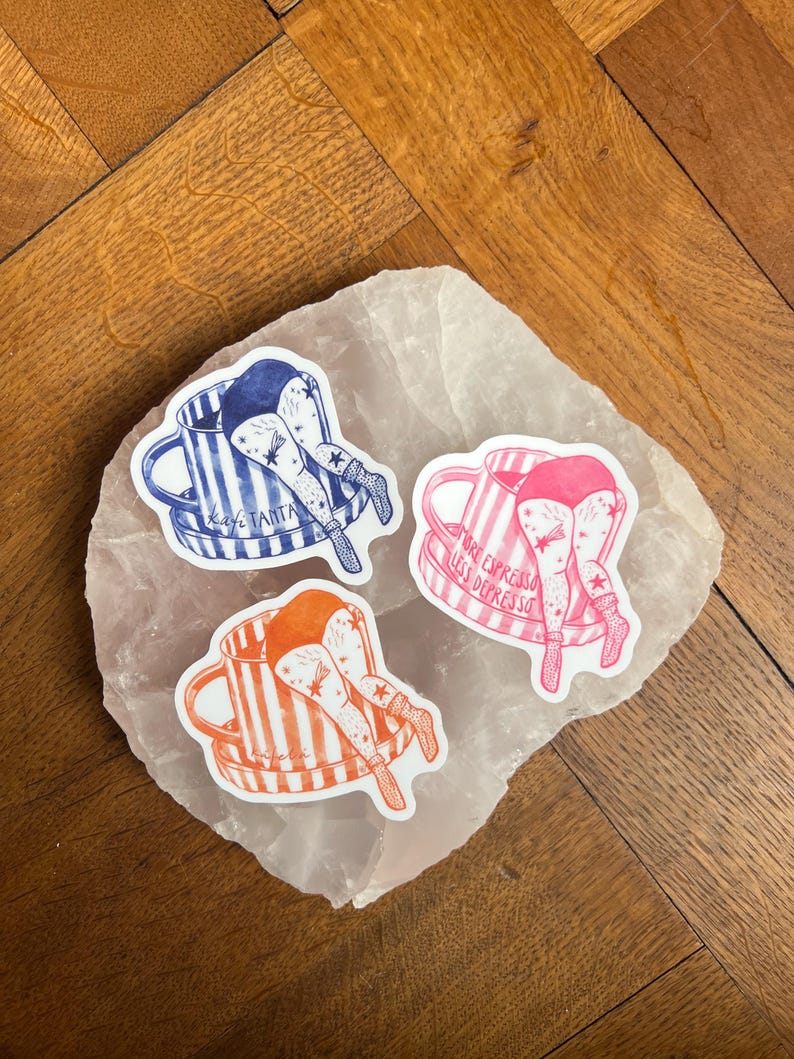 May include: Three stickers featuring a person's legs and rear end sticking out of a coffee mug. The mugs are blue and white striped, pink and white striped, and orange and white striped. The stickers have text that reads "Kaye Tanta" and "More Espresso Less Depresso".