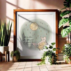 May include: A framed print with a green watercolor background and a gold moon. The print features a line drawing of a person lying down with the text "Fall in love with taking care of yourself".