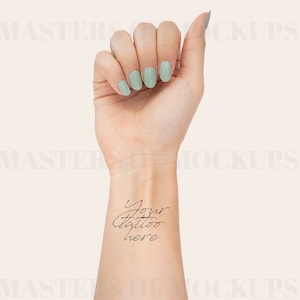 May include: A woman's wrist with light green nail polish and the text "Your tattoo here" written in black ink.