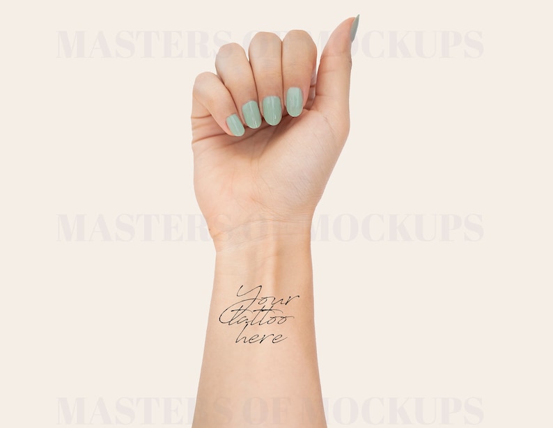 May include: A woman's wrist with light green nail polish and the text "Your tattoo here" written in black ink.