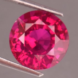 Peut inclure: Une pierre précieuse de rubis rose vif avec une coupe ronde et un design facetté. La pierre précieuse est sertie dans un sertissage transparent et clair.